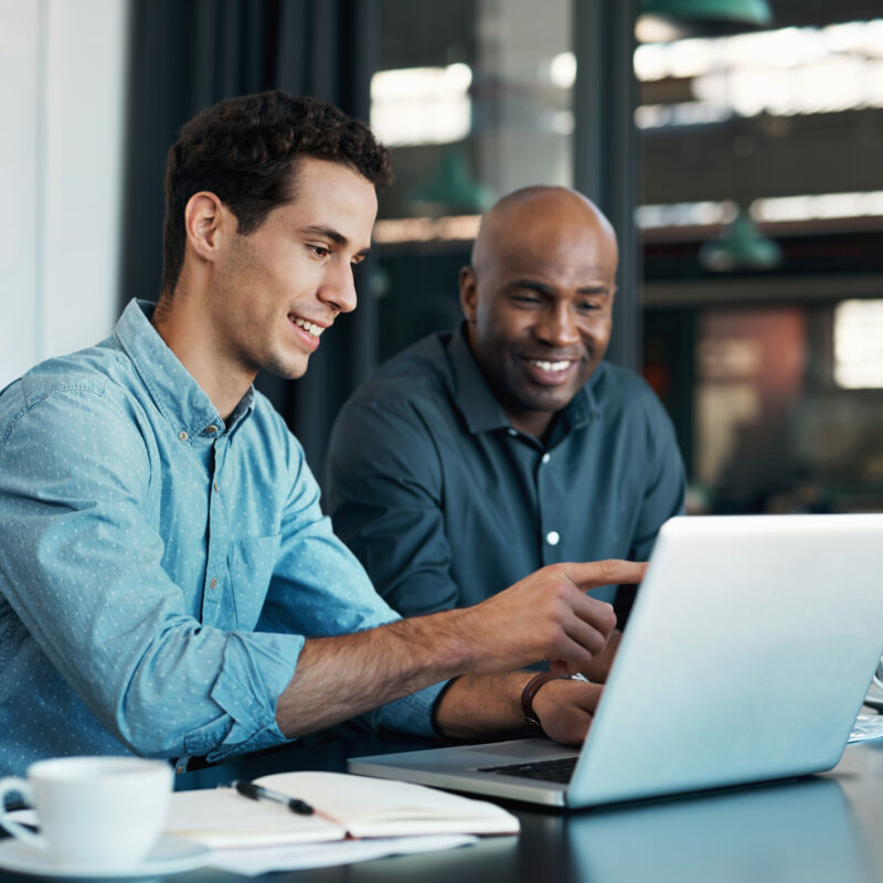 Two men on a laptop reviewing personal financial advice and retirement planning