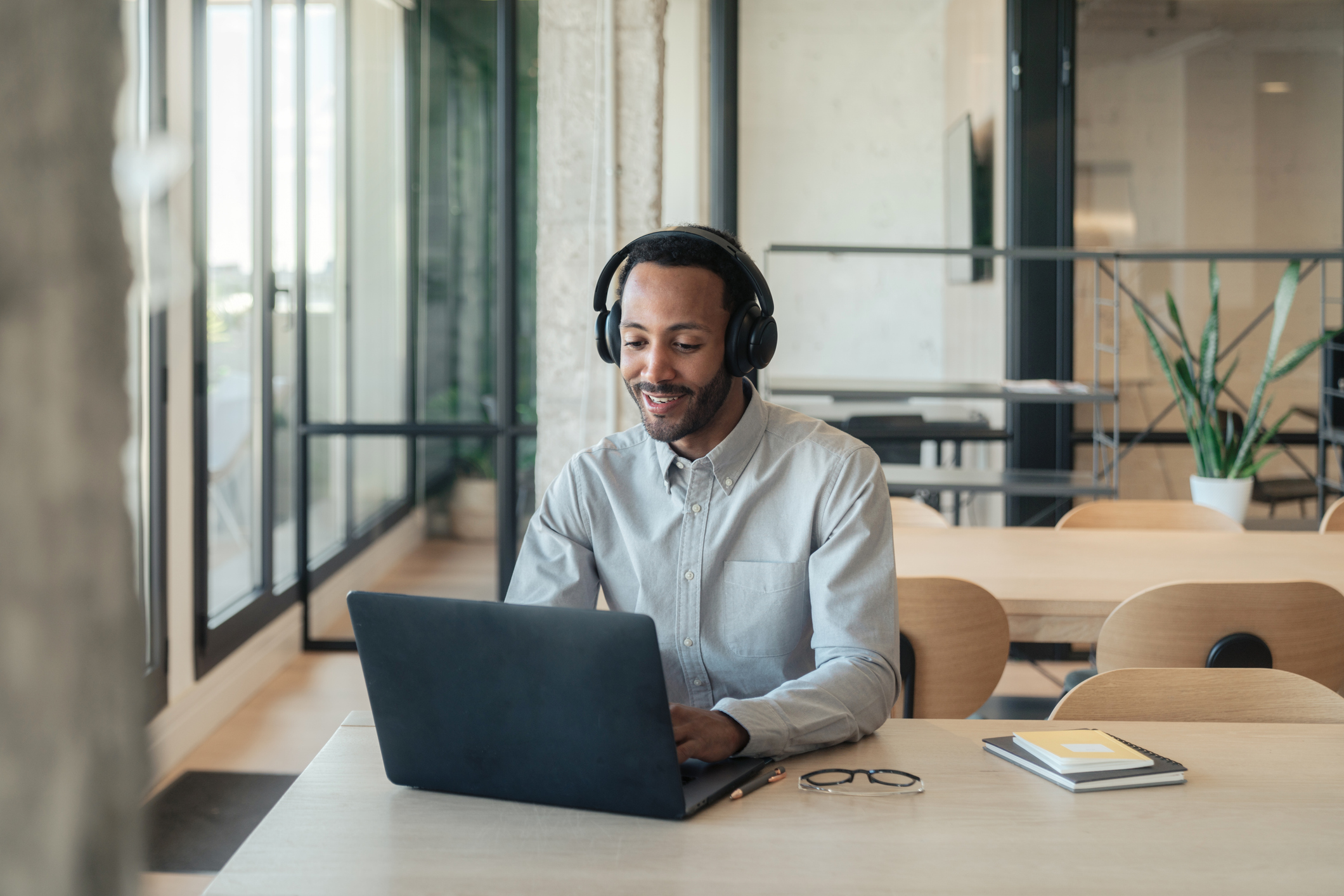 Casual man working on laptop with headphones